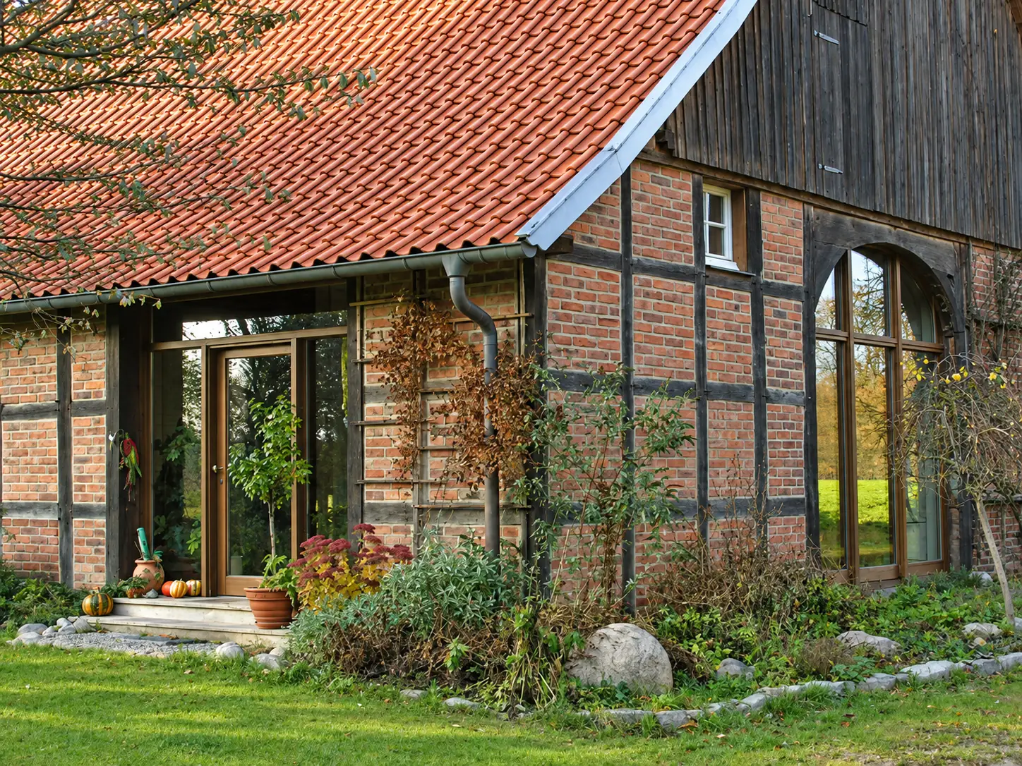 Saniertes Fachwerkhaus mit großen verglasten Öffnungen und erhaltenem Ziegelmauerwerk